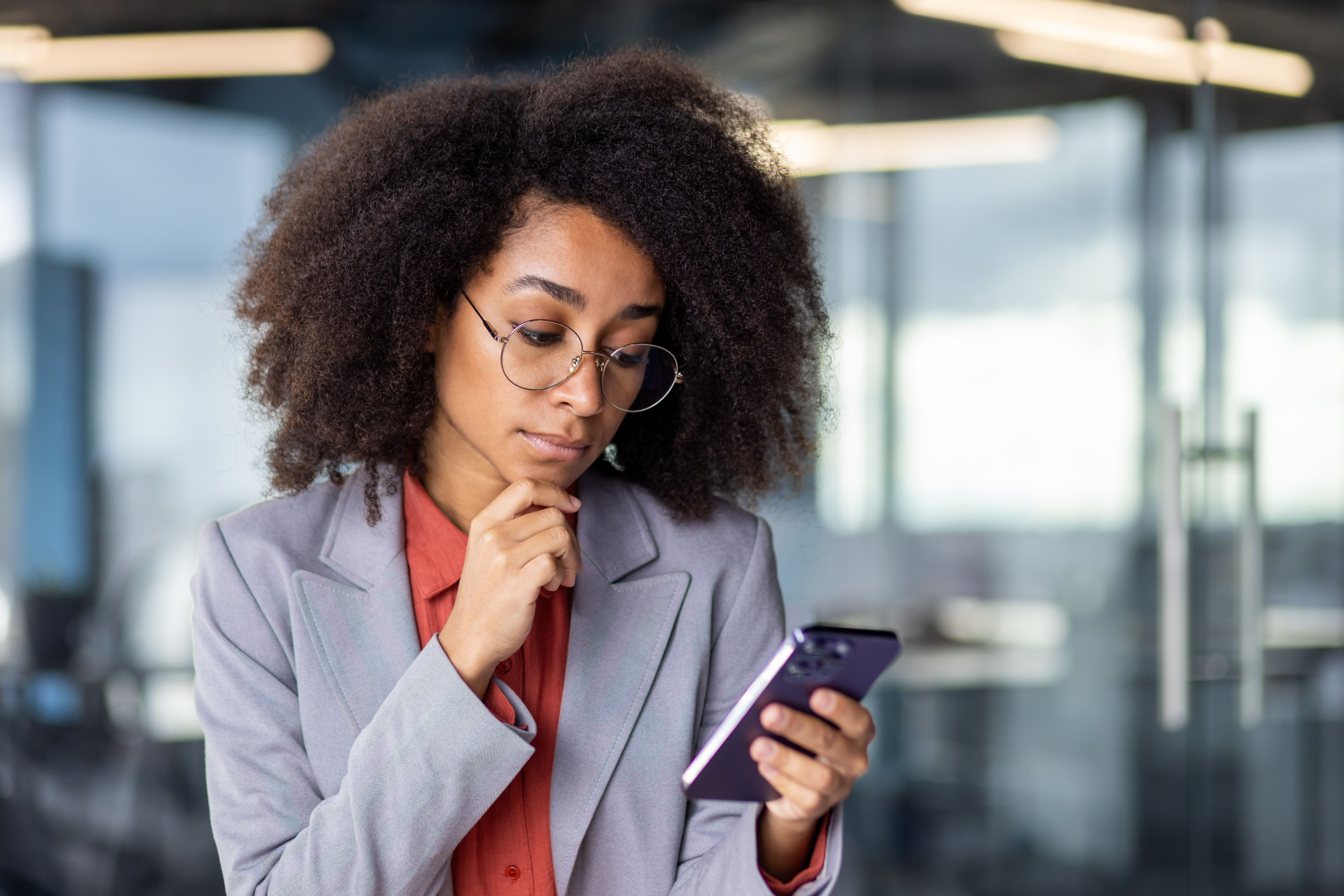 Young afro-latina woman looking questionable at phone