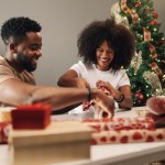 African American couple wrapping Christmas presents